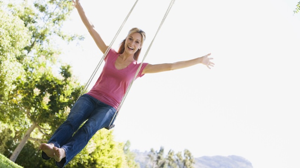 Woman on tree swing smiling